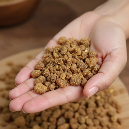 Hand holding raw hing with a wooden bowl in the background